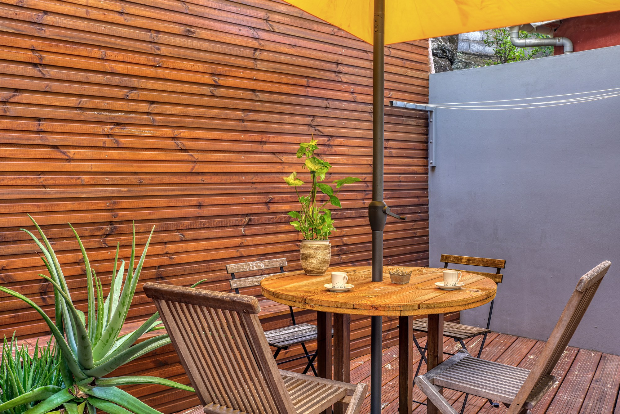 Terrasse privative du T2 ouvrant sur l'allée qui mène à l'espace spa de la résidence