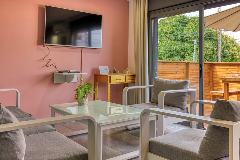 Salon du T3 de 120 mètres carrés, avec canapé et grande baie vitrée ouvrant sur la terrasse