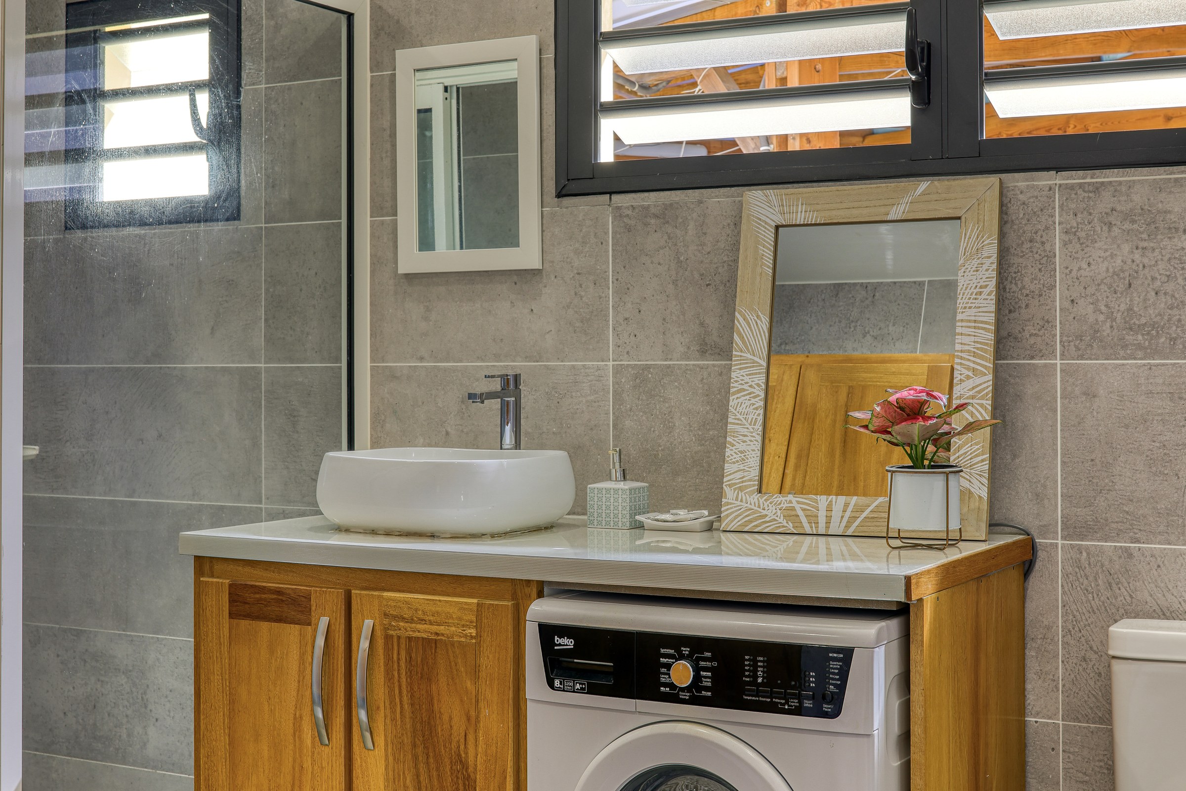 Salle de bains du T3 avec meuble vasque, lave-linge et douche à l'italienne