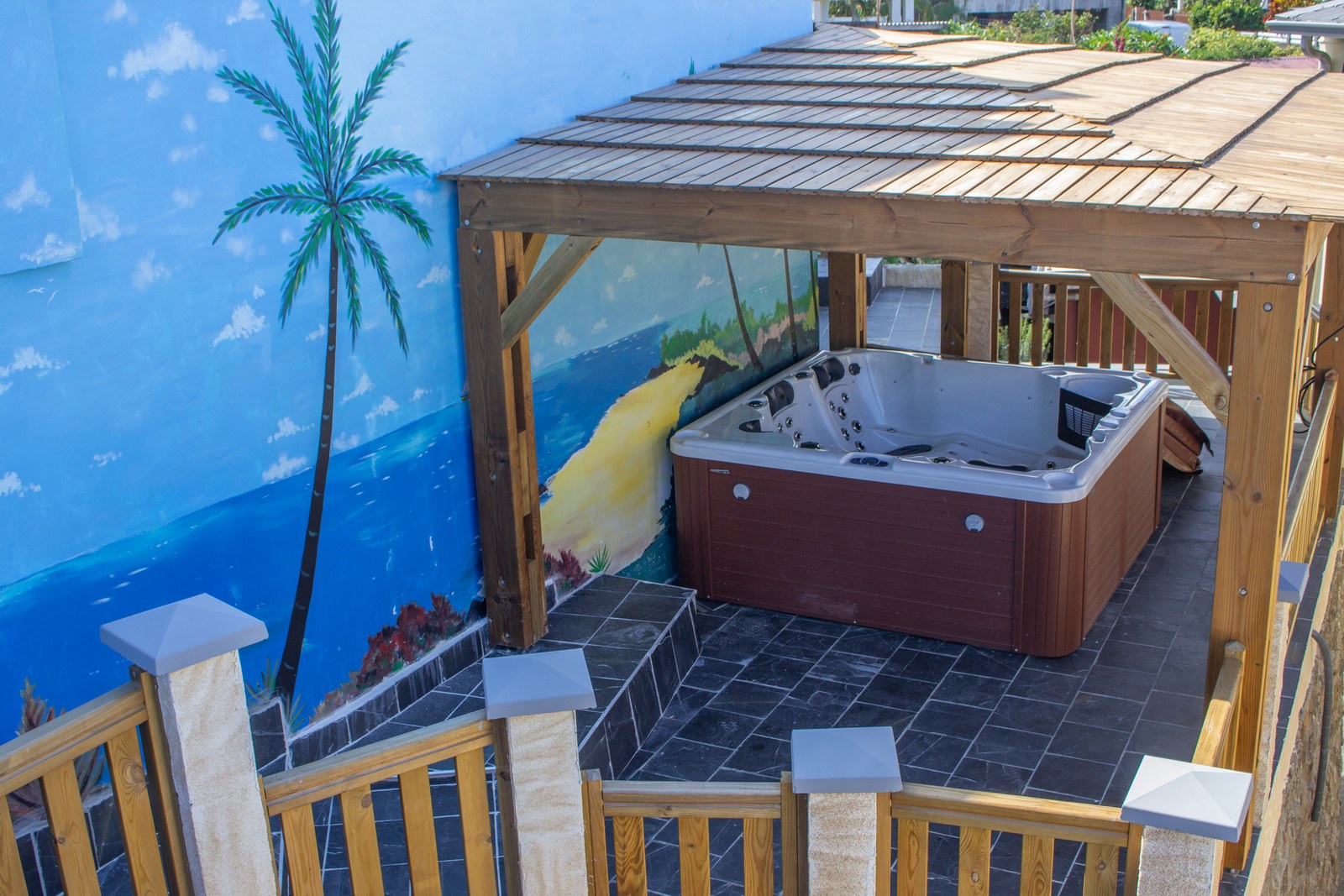 The shared spa under its pergola, in the garden of the residence