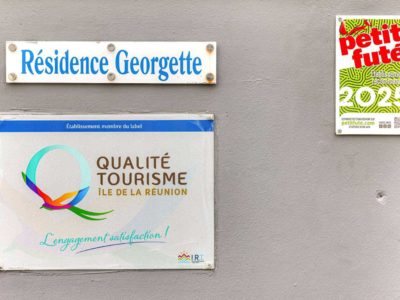 Plaques Qualité Tourisme Île de La Réunion et Petit Futé 2025 sur le mur de la Résidence Georgette