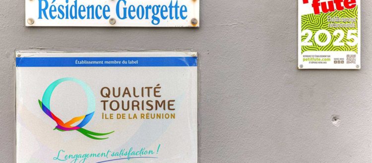 Plaques Qualité Tourisme Île de La Réunion et Petit Futé 2025 sur le mur de la Résidence Georgette