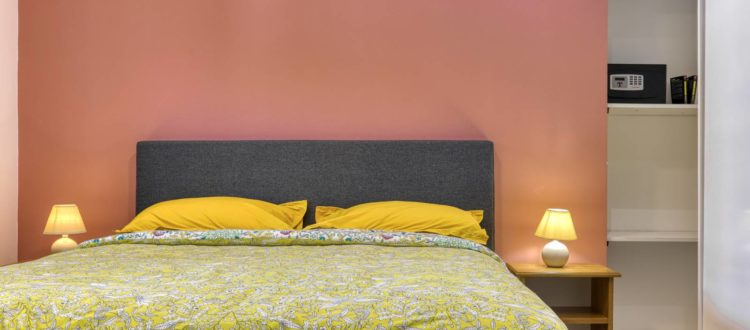 Lit double dans une chambre moderne de l'appartement T2 à la Résidence Georgette