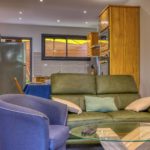 Salon design avec TV et canapé face à la cuisine – Appartement T2 Terre-Sainte