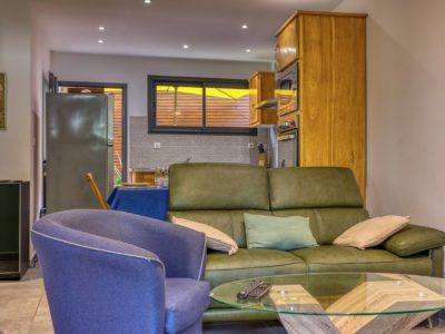 Salon design avec TV et canapé face à la cuisine – Appartement T2 Terre-Sainte