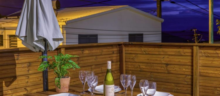 Terrasse bois éclairée avec table dressée pour le dîner