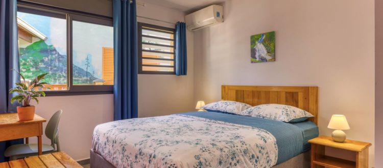 Lit double dans la chambre principale du T3 à la Résidence Georgette à Terre-Sainte