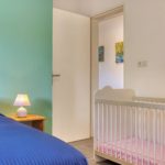 Chambre du T3 aménagée avec un lit bébé à la Résidence Georgette
