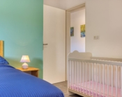 Chambre du T3 aménagée avec un lit bébé à la Résidence Georgette