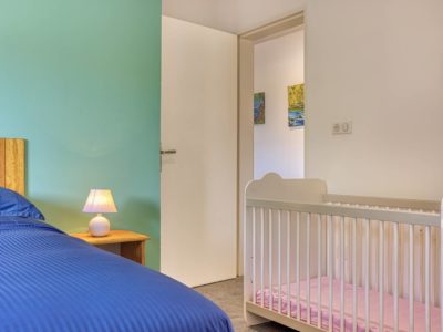 Chambre du T3 aménagée avec un lit bébé à la Résidence Georgette