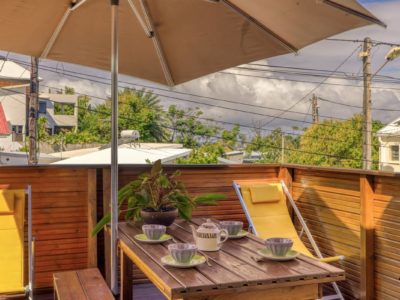 Terrasse en bois avec parasol, chaises longues et table à déjeuner